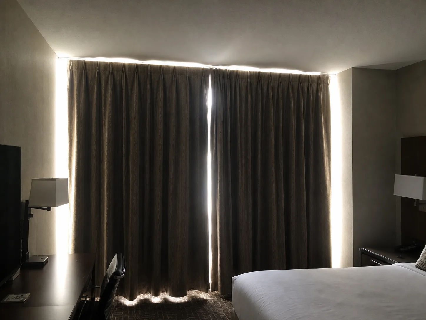 Hotel blackout drapes with light leaking around the edges