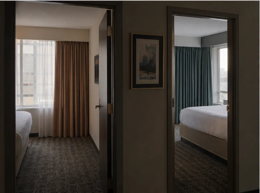 Two adjacent hotel rooms with visibly different window treatment specs
